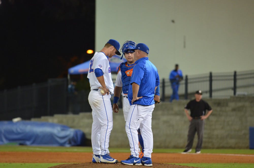 <p>Kevin O'Sullivan and Mike Rivera meet with Logan Shore on the mound during Florida's 4-3 win against Missouri on March 18, 2016, at McKethan Stadium. </p>