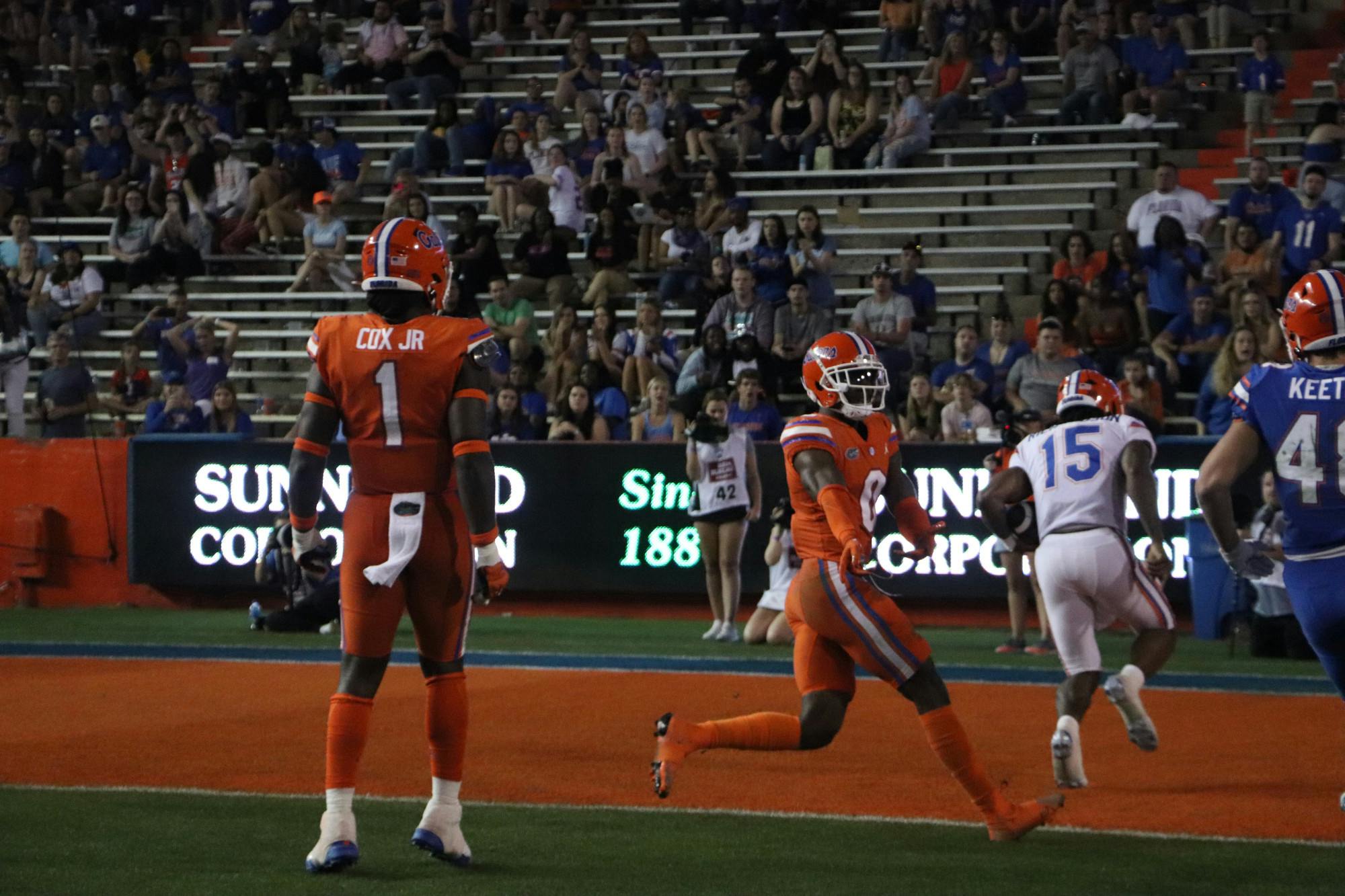 Blue team quarterback Anthony Richardson runs past Orange defenders Brenton Cox Jr. and Trey Dean III to get into the endzone for a touchdown during Thursday night&#x27;s exhibition. 