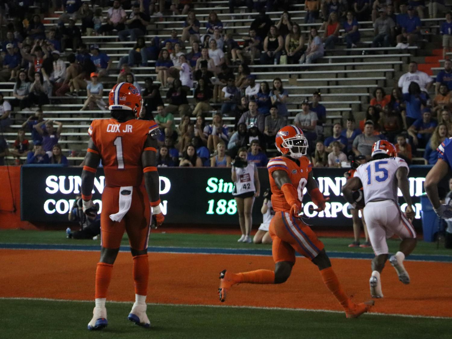 Blue team quarterback Anthony Richardson runs past Orange defenders Brenton Cox Jr. and Trey Dean III to get into the endzone for a touchdown during Thursday night&#x27;s exhibition. 