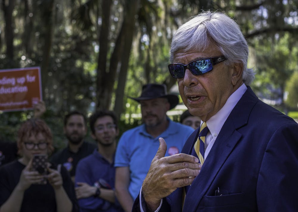 Jackson Sasser, the president of Santa Fe College, addresses a crowd of about 60 protesters Tuesday afternoon on campus. The crowd, made up of faculty, students and other activists, gathered during a Board of Trustees meeting to pressure administrators into giving adjunct faculty a vote on whether or not to join a union. Protesting faculty members believe the administration has taken steps to avoid the formation of a union.
