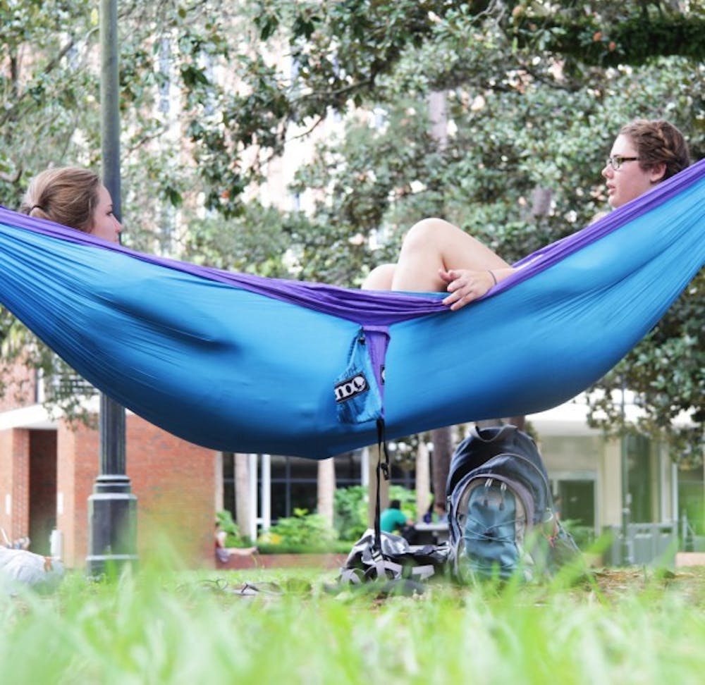 <p>Anna Ellis, an 18-year-old nursing freshman, and Caroline Hament, a 19-year-old exploratory freshman, lounge in a hammock on the Plaza of the Americas on Thursday.</p>