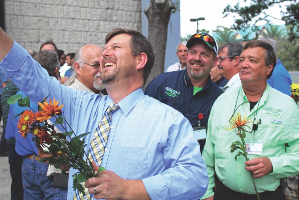 Gainesville Mayor Lauren Poe takes a selfie with city workers in front of Gainesville City Hall, located at 200 E. University Ave., on Thursday. Poe and city commissioners gave flowers to thank workers for helping after Hurricane Irma.