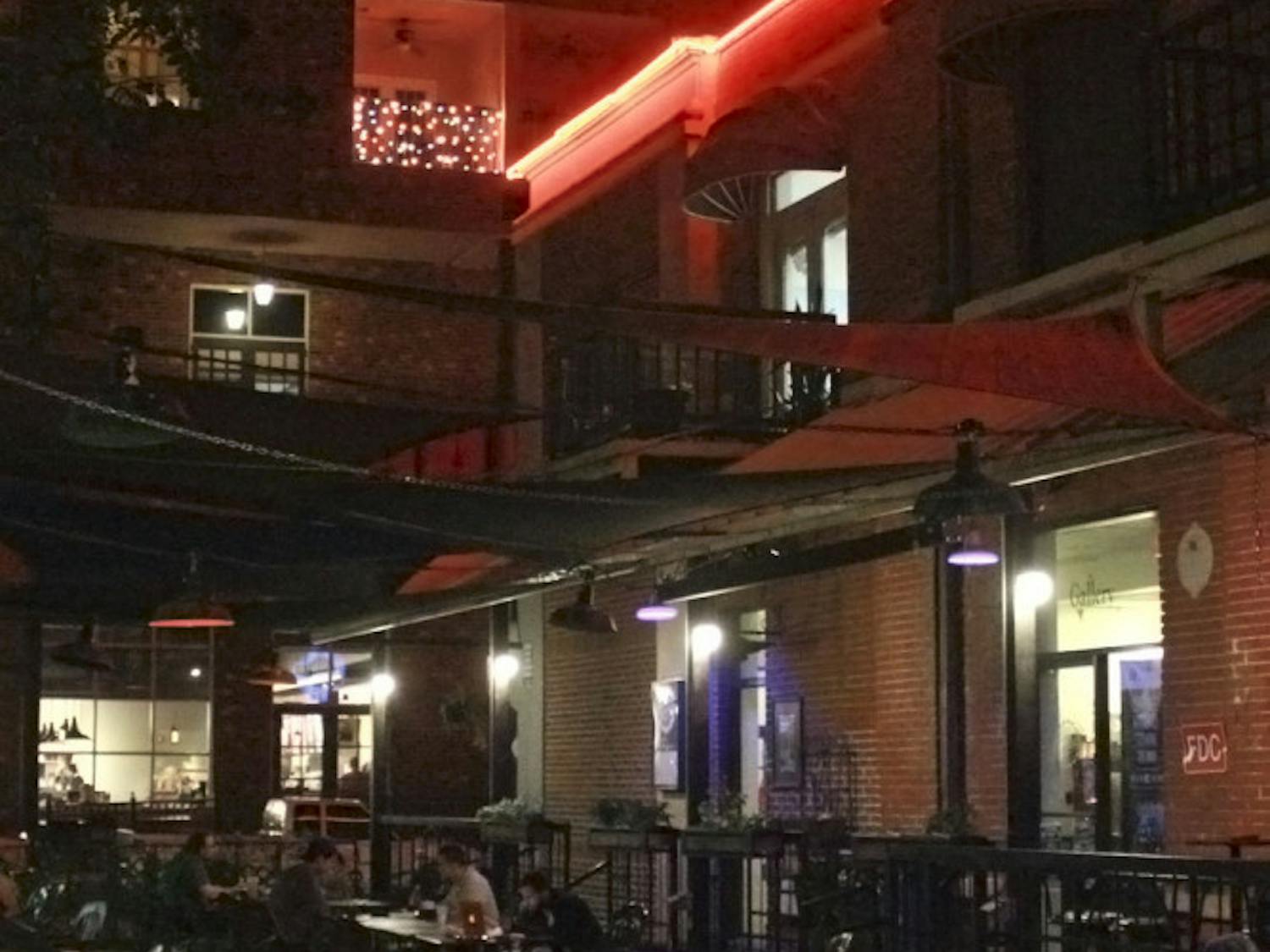 Patrons eat and drink outside Maude’s Classic Cafe at Sun Center in downtown Gainesville on Nov. 29, 2015. Holiday lights adorned apartments above and temperatures approached a low of 57 degrees.