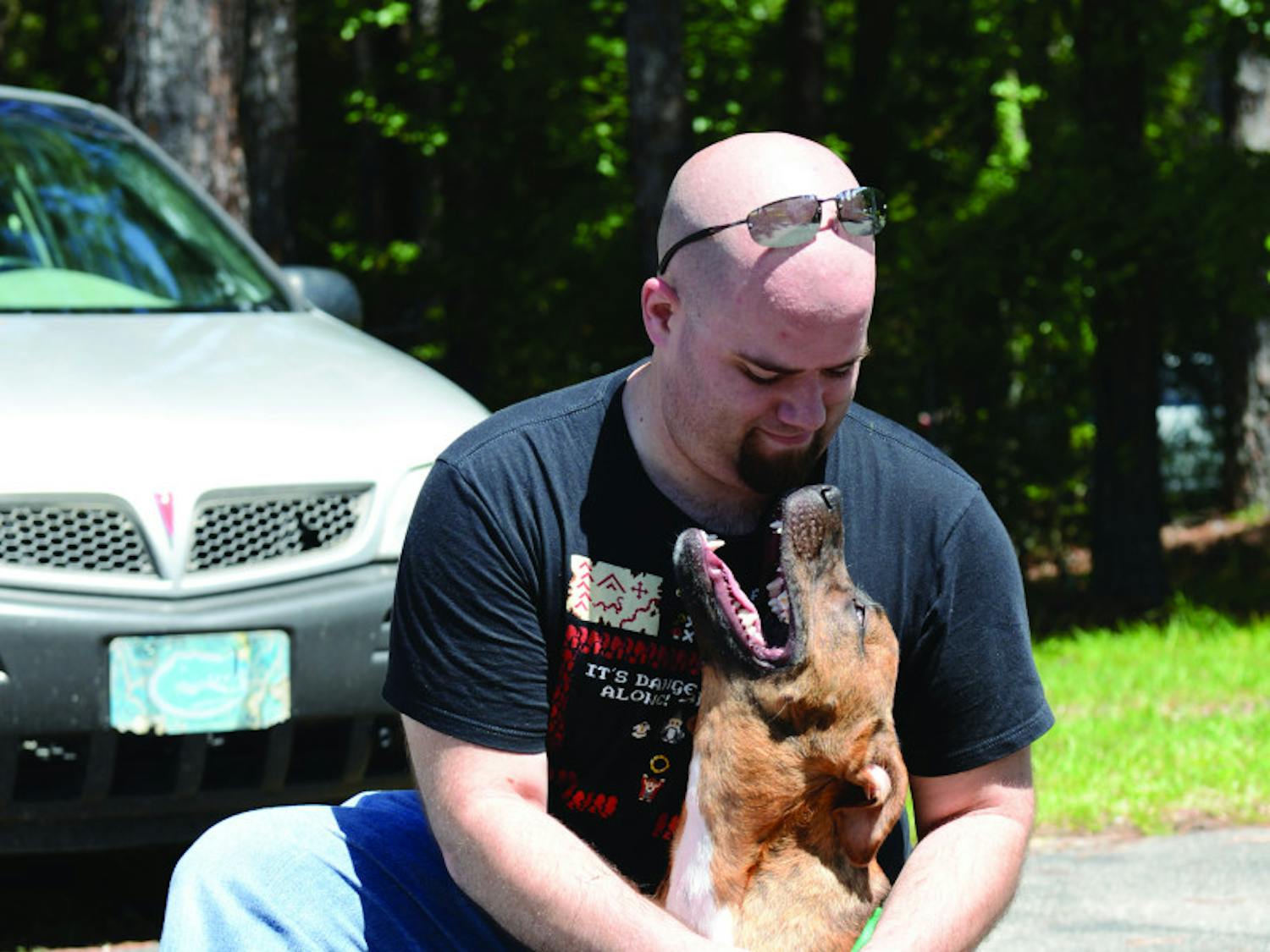 Tim Forbes, 29, puts a leash on his new dog, Graham, at the Summer Lovin’ Adoptathon on Saturday. The event found a new home for more than 180 cats and dogs.