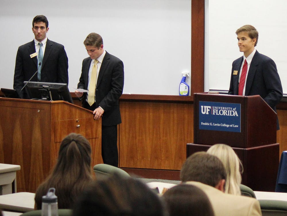 Sen. Jason Richards (center) presents the resolution supporting the installation of solar power-doks on campus on Tuesday evening.