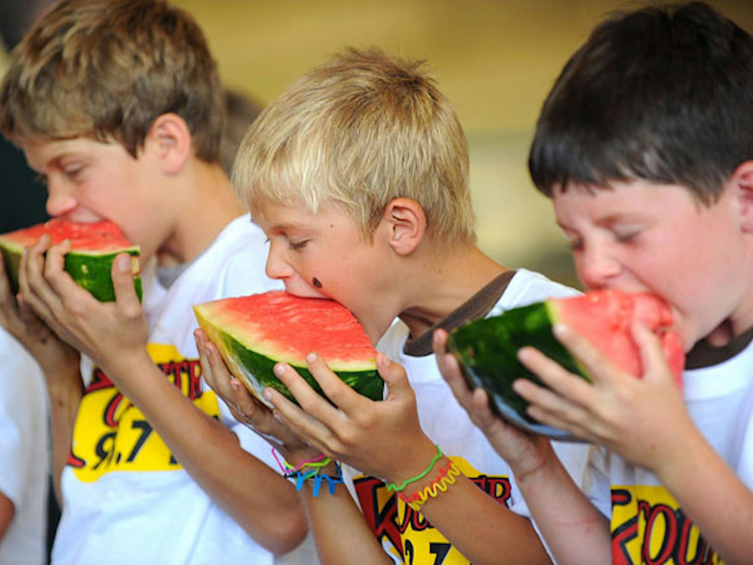 Zion Barber, left, Jacob Musselwhite and Colton Crane, right, sink their teeth into pieces of watermelon during the watermelon-eating contest at the 65th annual Newberry Watermelon Festival at the Canterbury Equestrian Showplace in 2010.