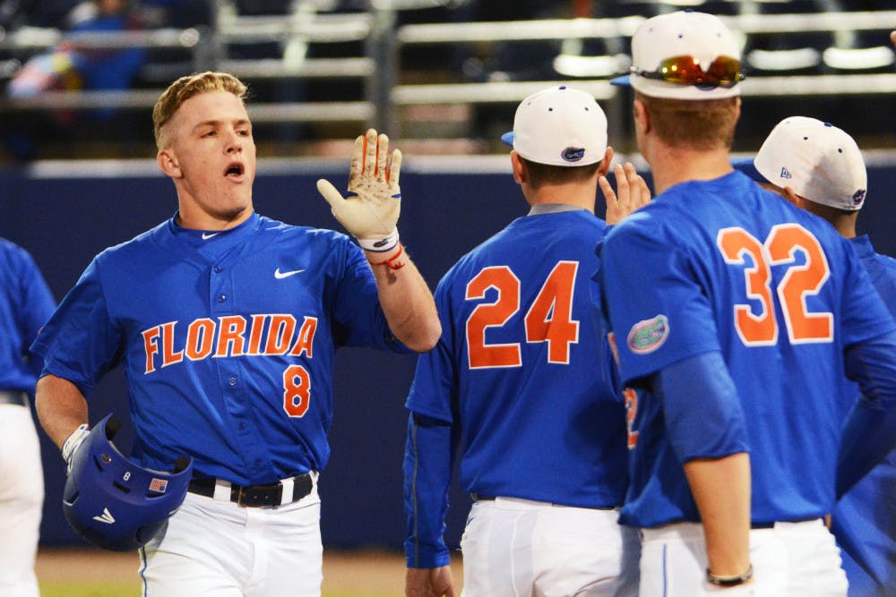 <p>Harrison Bader (8) celebrates with teammates following his second home run during Florida's 22-3 win against Rhode Island on Feb. 14 at McKethan Stadium.</p>