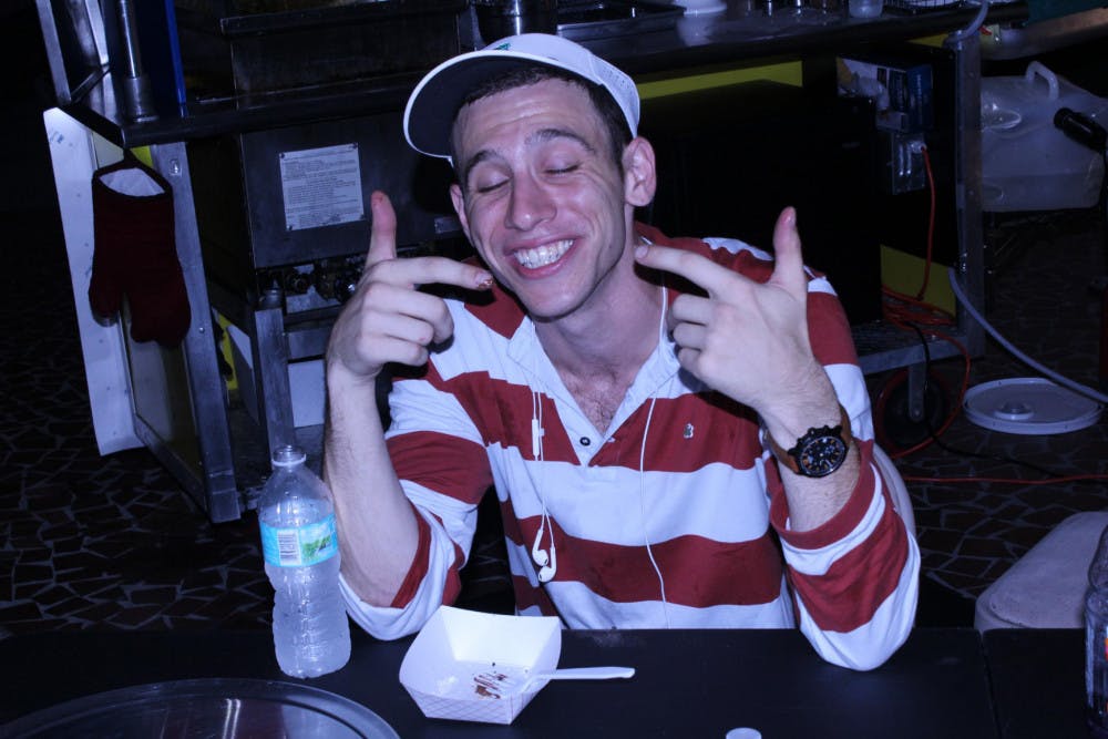 Andrew Congress, a UF event management senior, smiles after finishing his fried Oreos. “A Dank Cake a day keeps the stomach happy,” he said.