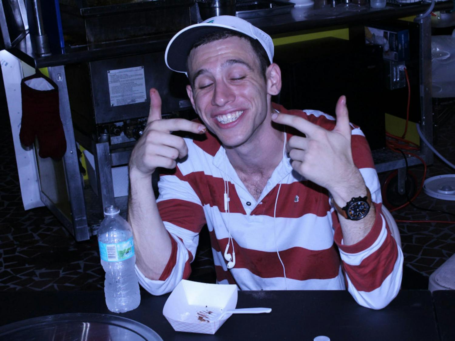 Andrew Congress, a UF event management senior, smiles after finishing his fried Oreos. “A Dank Cake a day keeps the stomach happy,” he said.