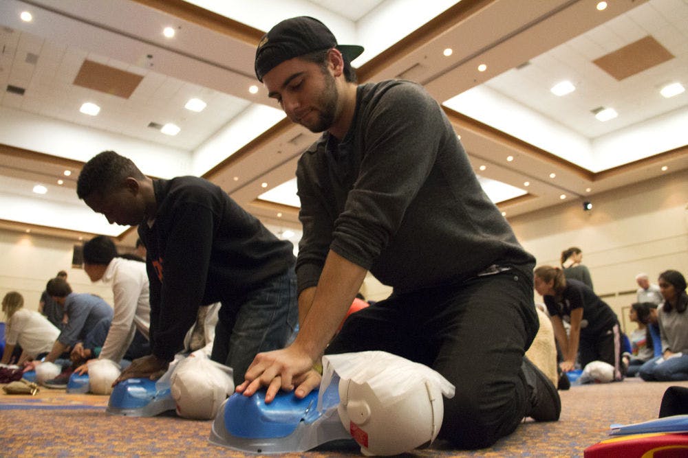 Joe O'Brien, a 21-year-old UF hospitality and tourism management senior, learns chest compressions as part of GatorSavers’ event in the Reitz Union Grand Ballroom on Saturday. About 500 participants came to the event to be trained and certified in CPR.