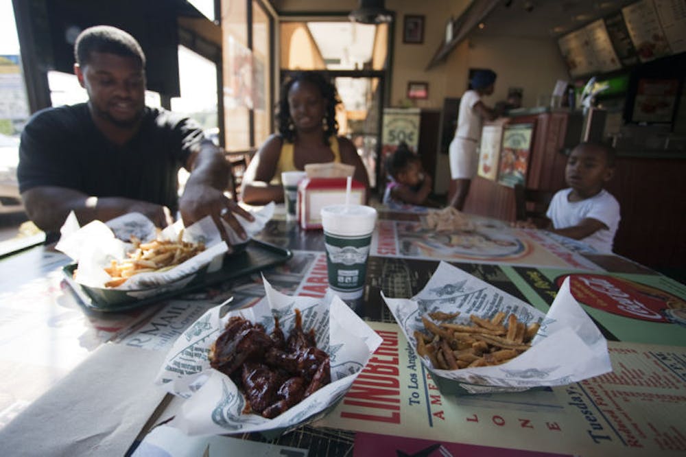 <p>Juan and Annie Jones, of Lake City, eat an early dinner with their children at the Wingstop on Southwest 20th Avenue. The opening of two additional branches in the Gainesville area is currently in the works.</p>