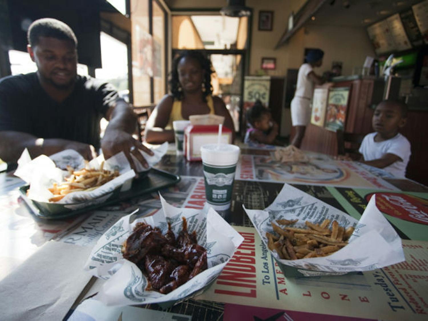 Juan and Annie Jones, of Lake City, eat an early dinner with their children at the Wingstop on Southwest 20th Avenue. The opening of two additional branches in the Gainesville area is currently in the works.