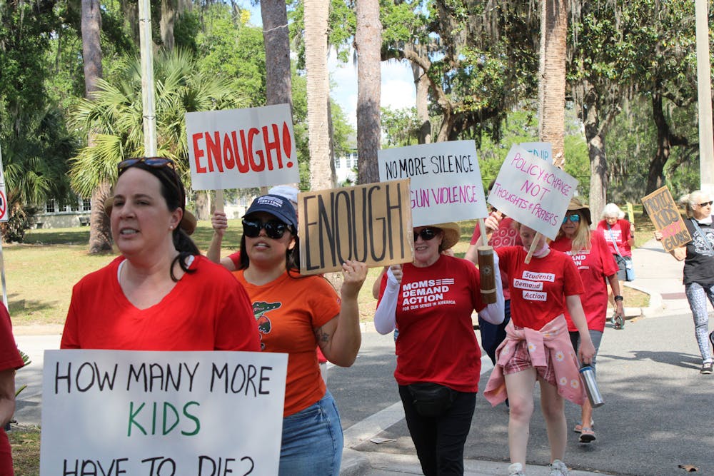 <p>Protesters with the Alachua County chapter of Moms Demand Action march down University Avenue on Tuesday, April 4, 2023.</p>