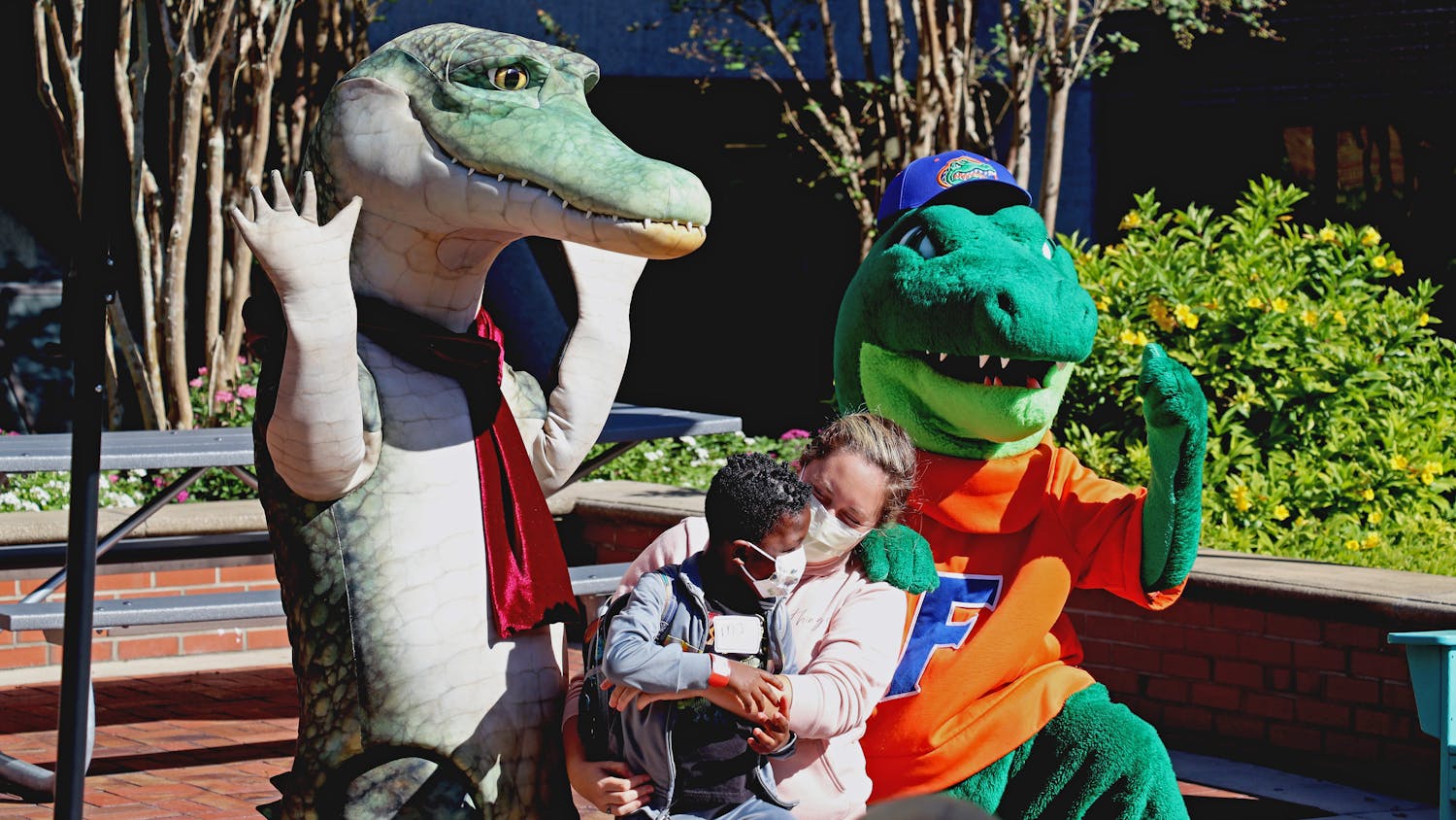 A child poses with Lyle the Crocodile and Albert the Gator at a UF Health Shands Hospital event where President Kent Fuchs and his wife read &quot;Lyle, Lyle, Crocodile&quot; to a group of children Tuesday, Oct. 4, 2022.