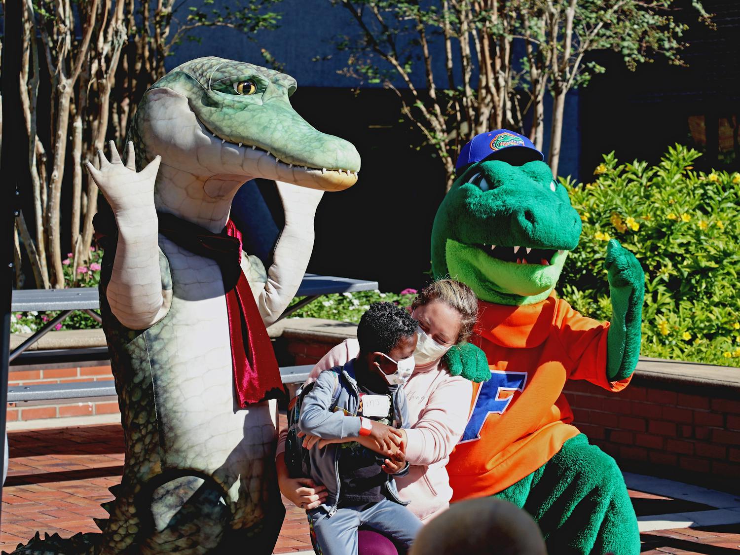 A child poses with Lyle the Crocodile and Albert the Gator at a UF Health Shands Hospital event where President Kent Fuchs and his wife read "Lyle, Lyle, Crocodile" to a group of children Tuesday, Oct. 4, 2022.