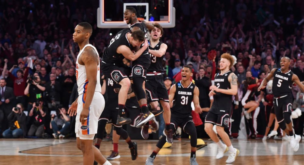 <p>UF forward Justin Leon walks off the court as South Carolina players celebrate their 77-70 win against Florida in the NCAA Tournament on Sunday at Madison Square Garden in New York City.</p>