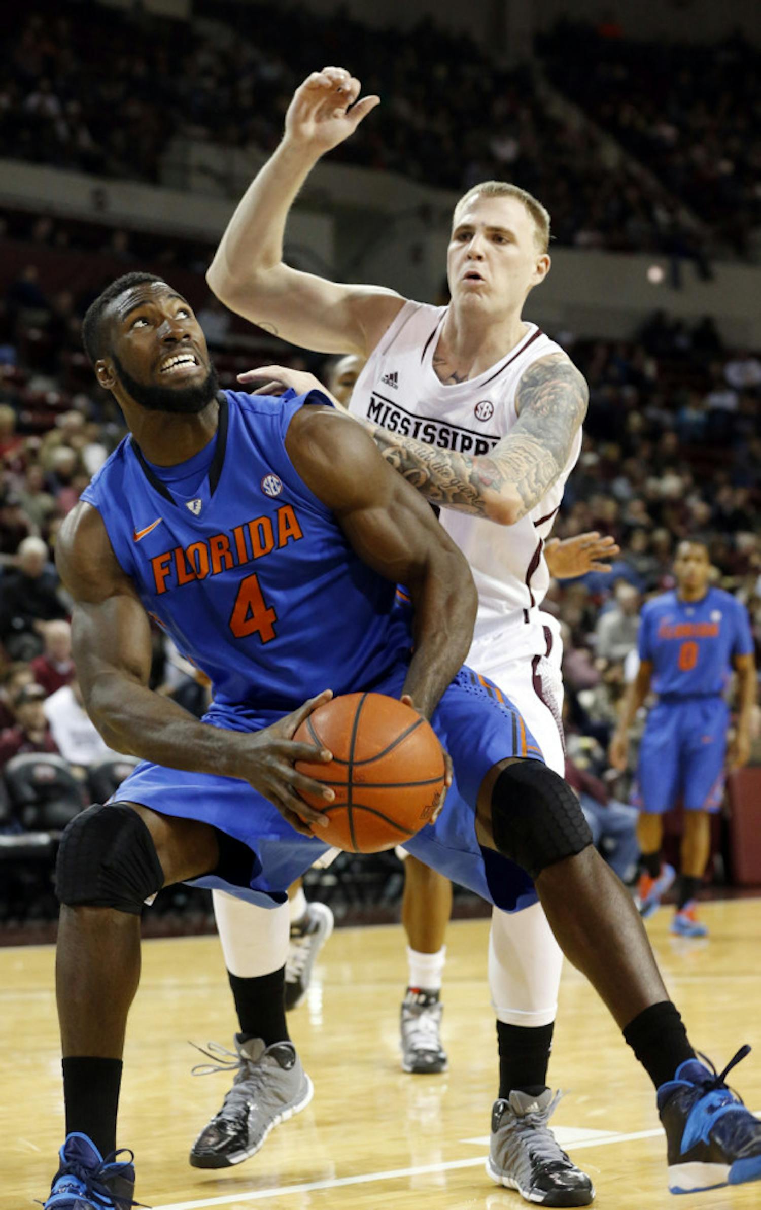 Patric Young (4) looks for an opening while Mississippi State’s Colin Borchert defends during UF’s 62-51 win in Starkville, Miss., Thursday.