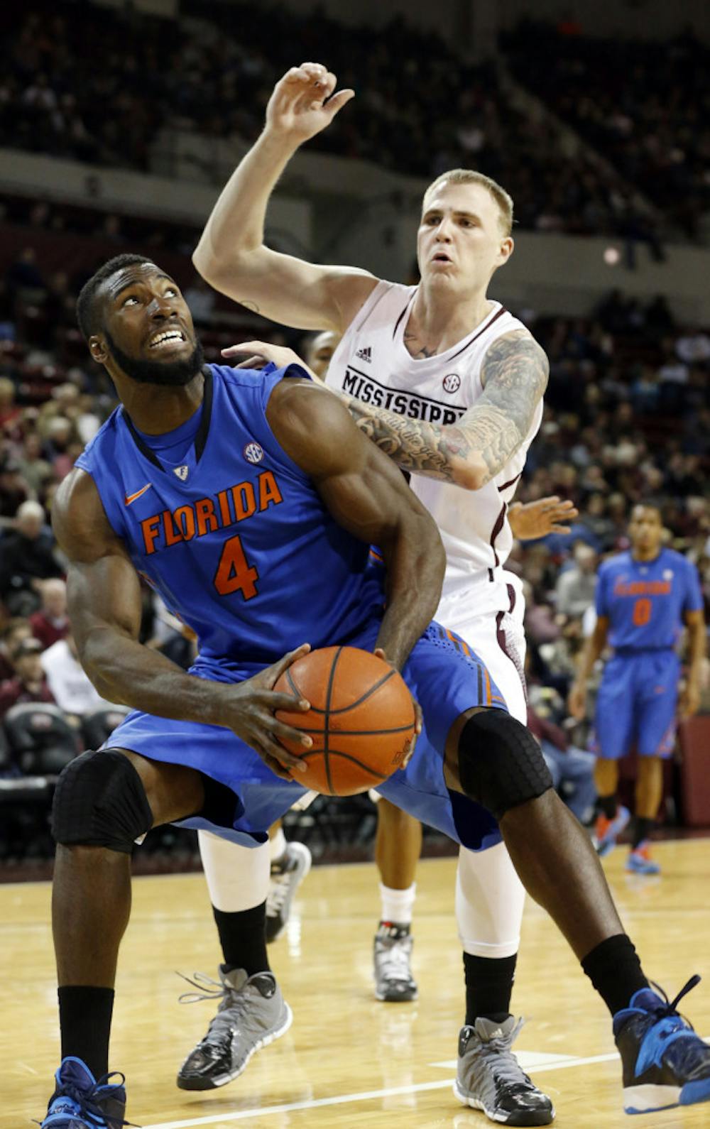 <p>Patric Young (4) looks for an opening while Mississippi State’s Colin Borchert defends during UF’s 62-51 win in Starkville, Miss., Thursday.</p>