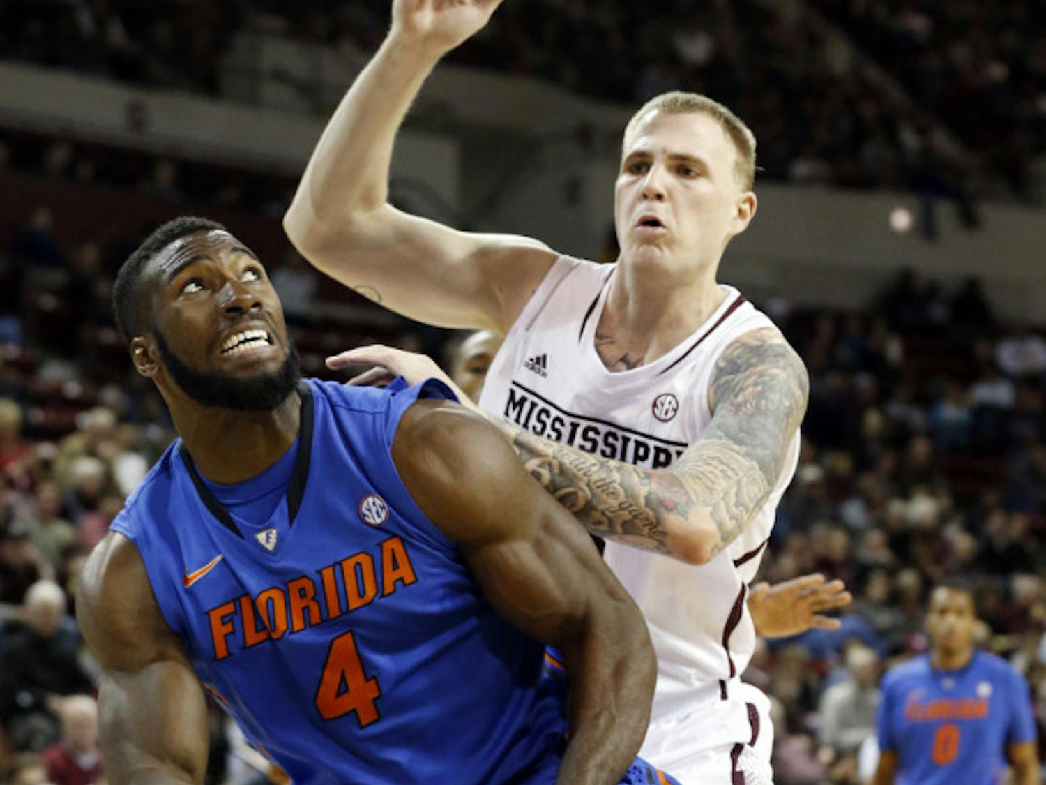 Patric Young (4) looks for an opening while Mississippi State’s Colin Borchert defends during UF’s 62-51 win in Starkville, Miss., Thursday.