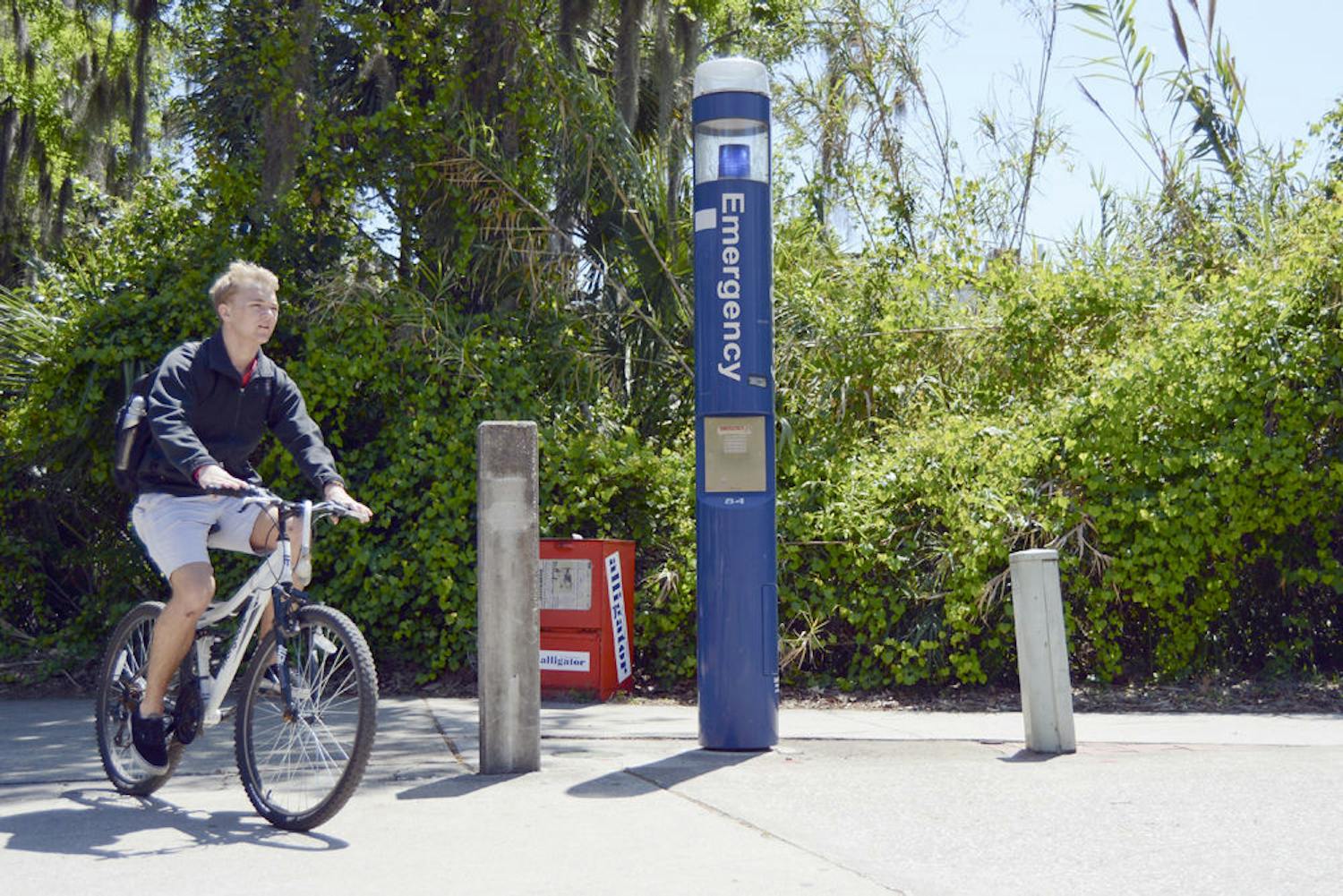 A student bikes past a blue light, which provides students with a direct line to UPD in case of an emergency, near Marston Science Library. Blue lights are typically added as new buildings are constructed on campus.