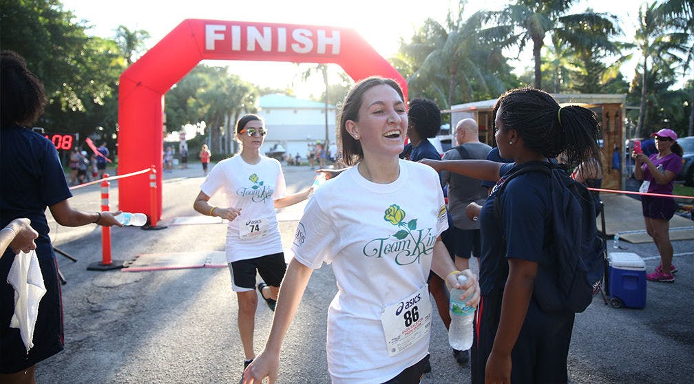 Sarah Lambert, center, 21, crossing the finish line of the Aid to Victims of Domestic Abuse for Hope in Delroy Beach.