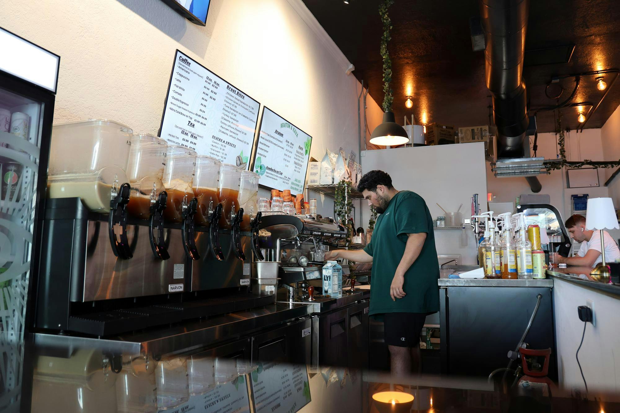Brew&amp;Root owner Bekir “Beck” Mansi works behind the counter inside the shop on West University Avenue in Gainesville, Fla., on Friday, Feb. 13, 2026.