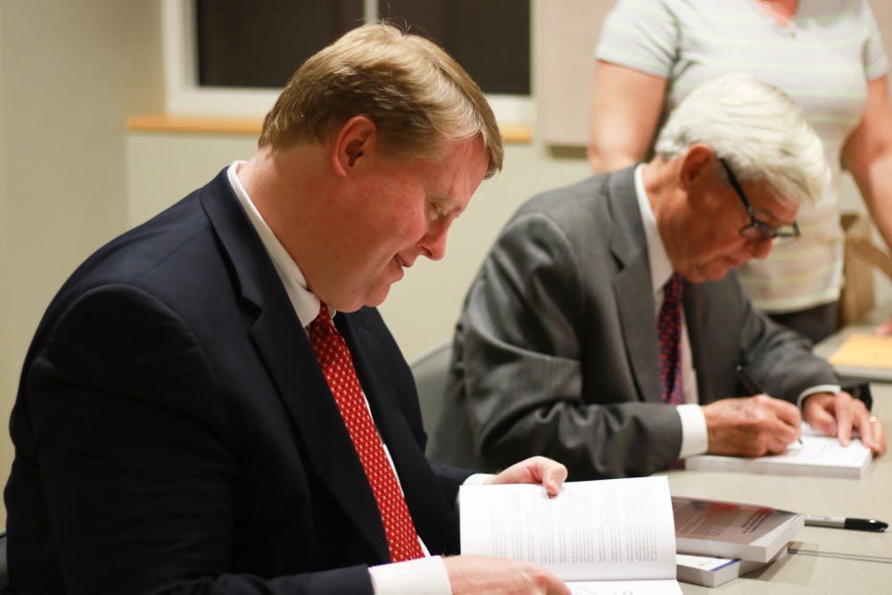Chris Hand, a UF alumnus and attorney, signs copies of the second edition of “America, the Owner’s Manual: Making Government Work For You,” with the book’s co-author, former Florida Gov. Bob Graham.