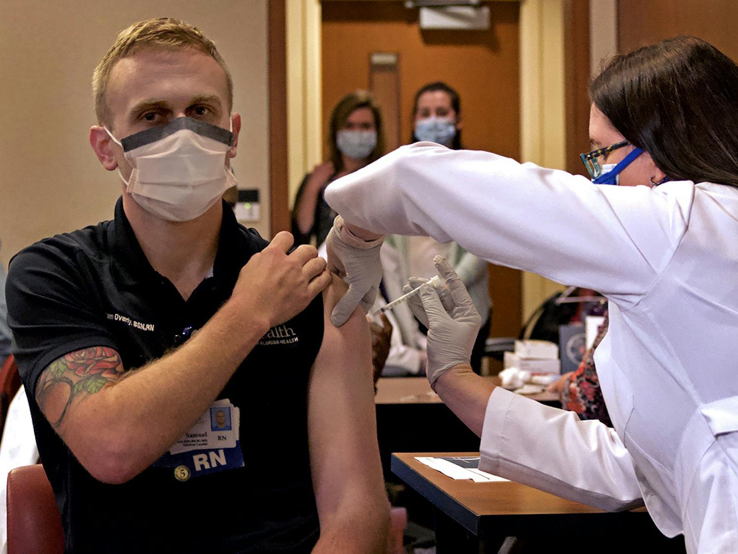 Samuel Overly, a UF Health clinical leader, is the first to get the Pfizer-BioNTech COVID-19 vaccine at UF Health Shands Cancer Hospital on Dec. 16, 2020. Suzy Wise administered the anticipated shot.