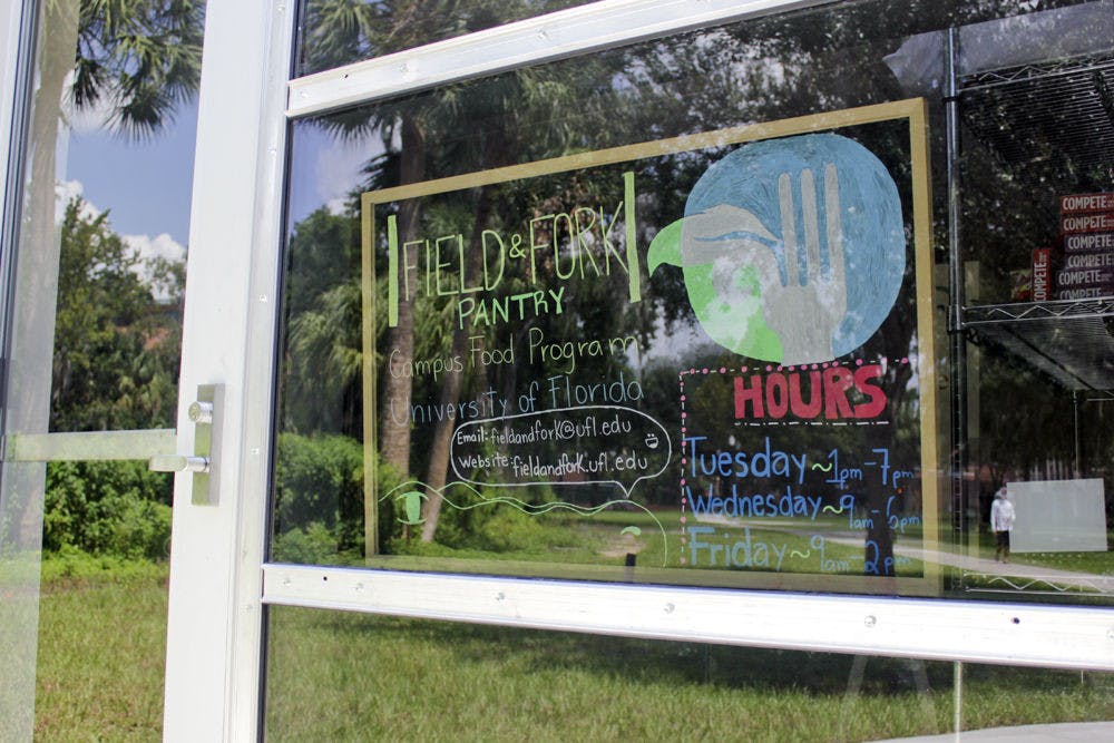 A sign in the window shows the hours of the Field and Fork Food Pantry on Sunday.