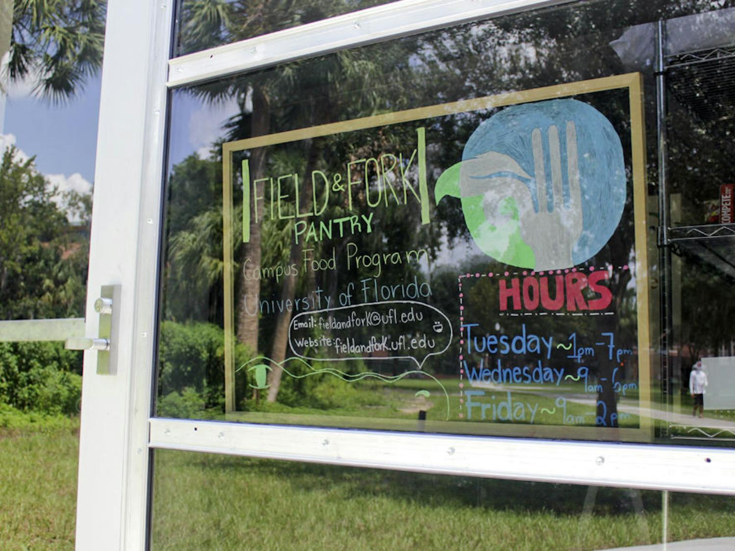 A sign in the window shows the hours of the Field and Fork Food Pantry on Sunday.