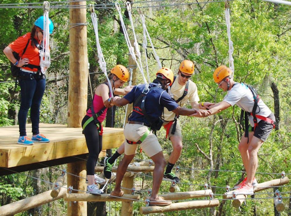 <p class="p1"><span class="s1">A group makes its way across the top level of the new UF Outdoor Team Challenge Courses at Lake Wauburg on Friday. About 20 people strapped on harnesses to climb to the top and zip line to the bottom.&nbsp;</span></p>