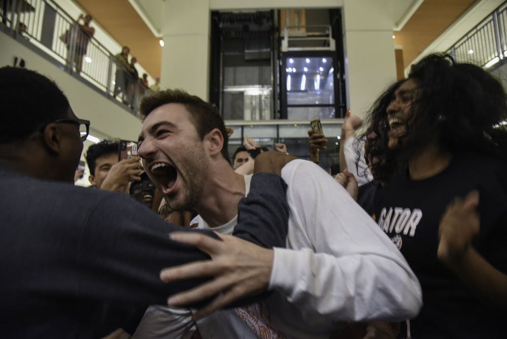 Trevor Pope, a 22-year-old UF law student and the UF Student Government president-elect, grabs ahold of Lauredan Official, a 21-year-old UF advertising junior and the vice president-elect, after finding out election results that were announced at the Reitz Union Wednesday night. 