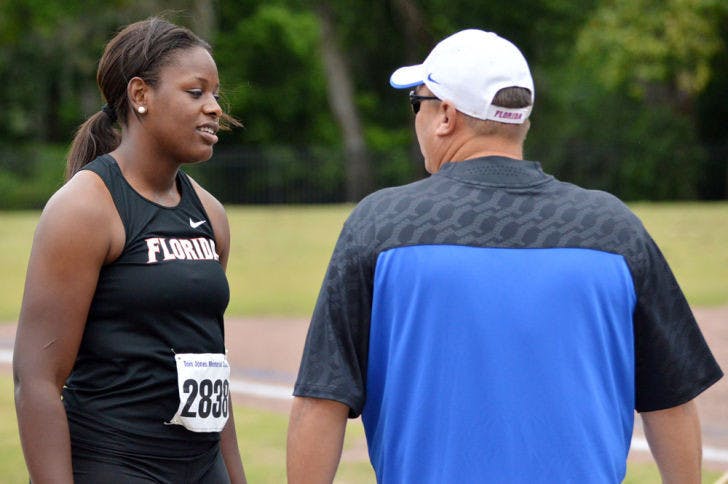 Jayla Bostic talks with throws coach Steve Lemke after one of her hammer throw attempts during the Tom Jones Memorial Invite on April 19, 2014, at Percy Beard Track.