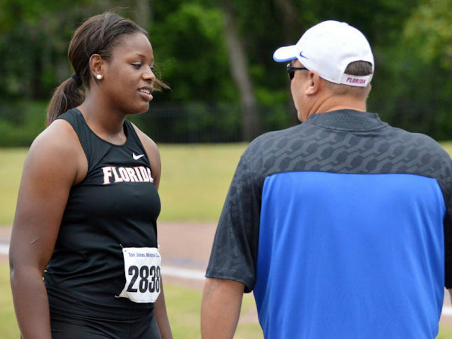 Jayla Bostic talks with throws coach Steve Lemke after one of her hammer throw attempts during the Tom Jones Memorial Invite on April 19, 2014, at Percy Beard Track.