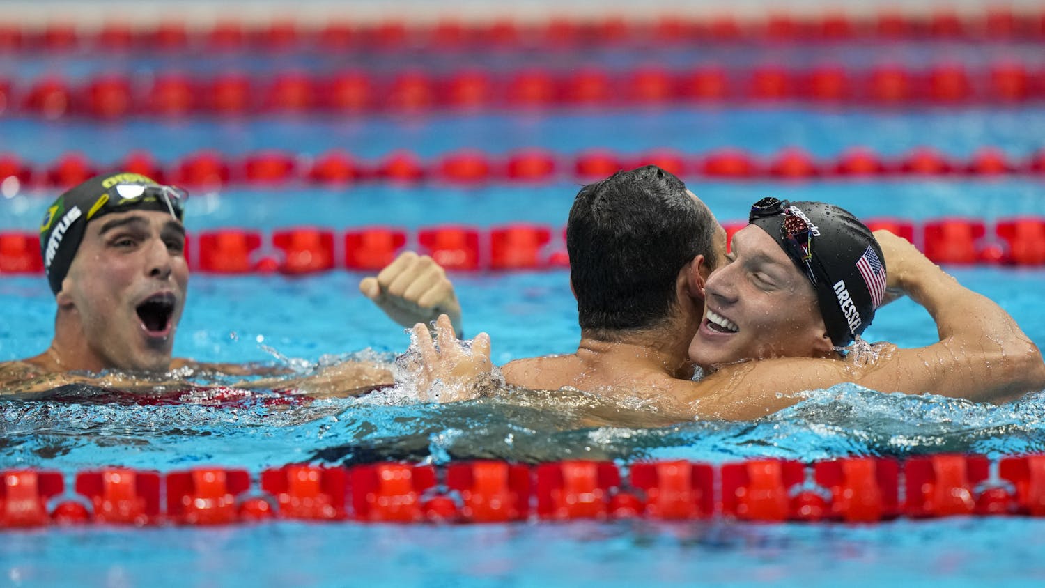 Caeleb Dressel, of United States, celebrates after winning the gold medal in a men's 50-meter freestyle fiat the 2020 Summer Olympics, Sunday, Aug. 1, 2021, in Tokyo, Japan. At left Bruno Fratus, of Brazil, celebrates winning the bronze medal. (AP Photo/David Goldman)