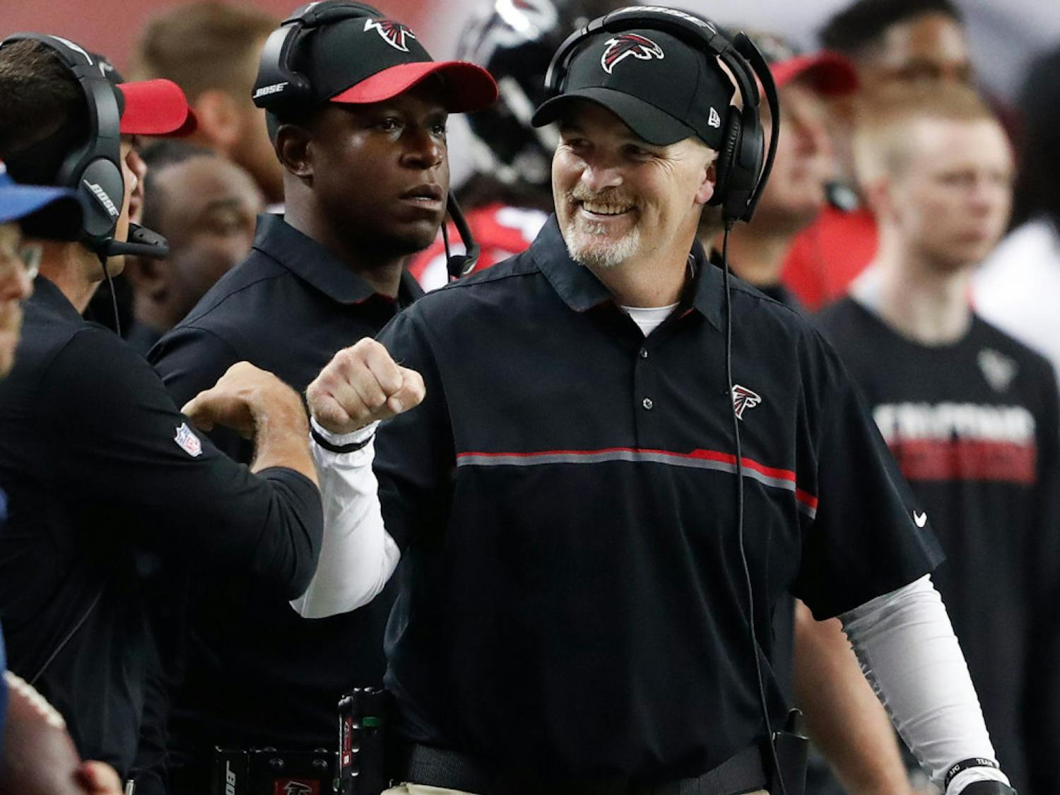 Atlanta Falcons head coach Dan Quinn fist bumps a coach after the Carolina Panthers were stopped during the first half of an NFL football game, Sunday, Oct. 2, 2016, in Atlanta. (AP Photo/John Bazemore)