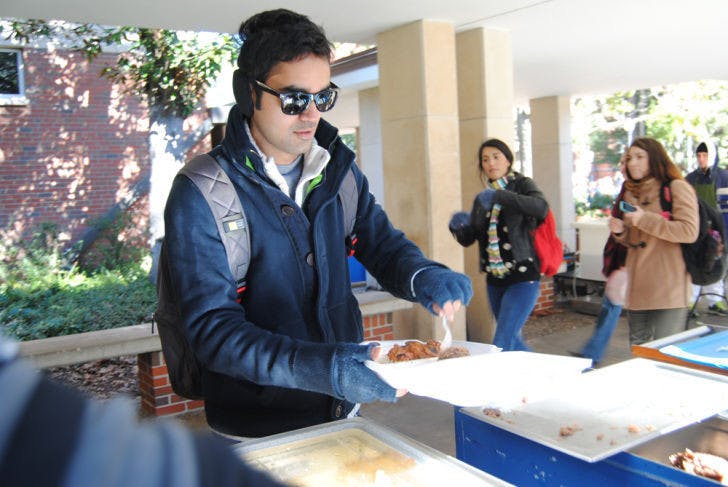 During his lunch hour, 26-year-old UF chemical engineering doctoral student Virat Upadhyay serves himself Krishna Lunch using their new to-go containers. Krishna staff has started using the containers in order to help keep food servings — and customers — warm.