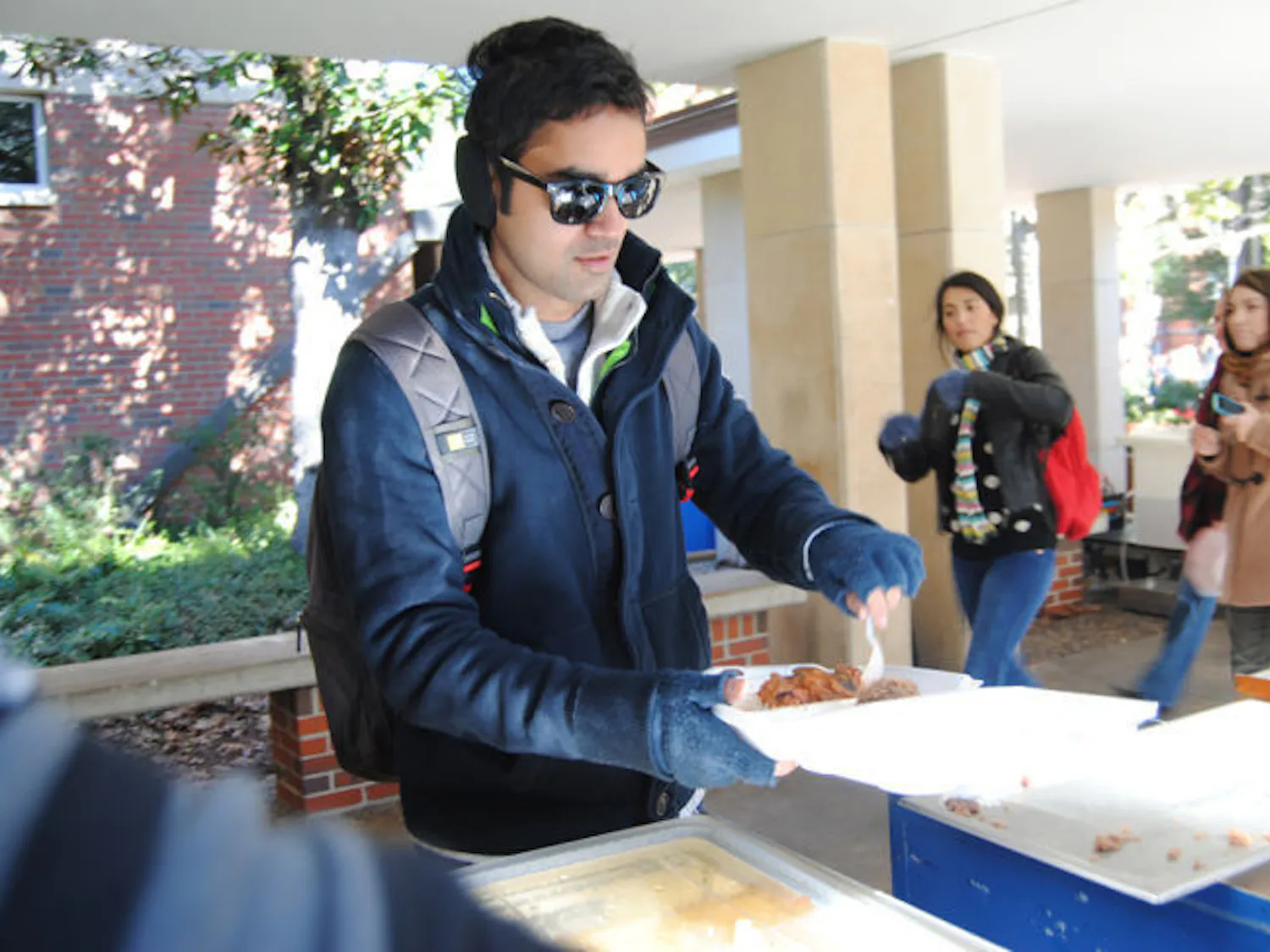 During his lunch hour, 26-year-old UF chemical engineering doctoral student Virat Upadhyay serves himself Krishna Lunch using their new to-go containers. Krishna staff has started using the containers in order to help keep food servings — and customers — warm.