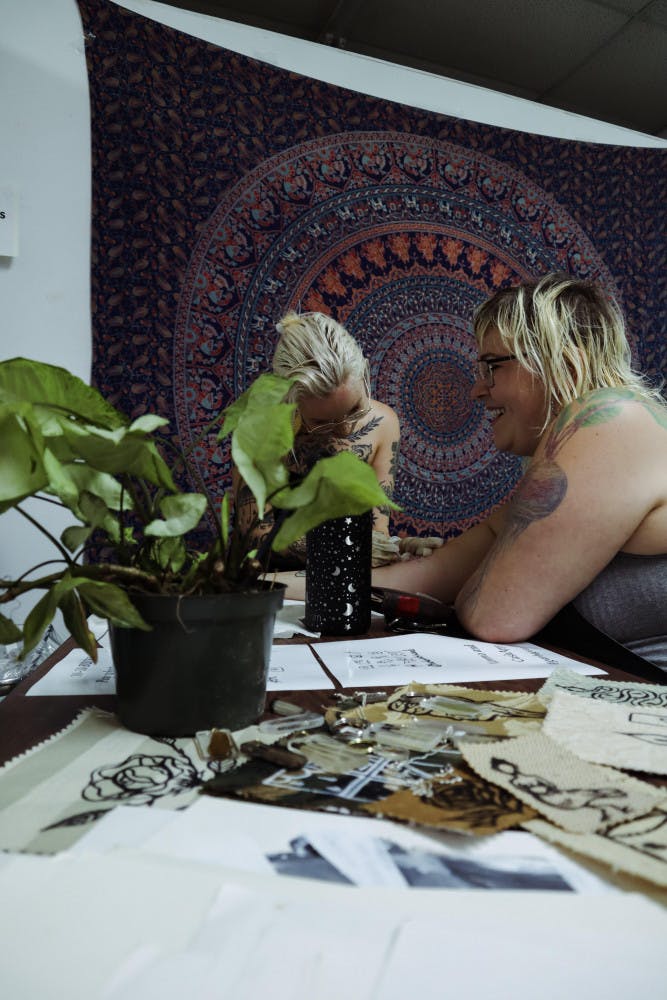 Julia Sanders tattoos attendee Amada Kaschkarow at the Beauty Marks pop-up show Saturday night.