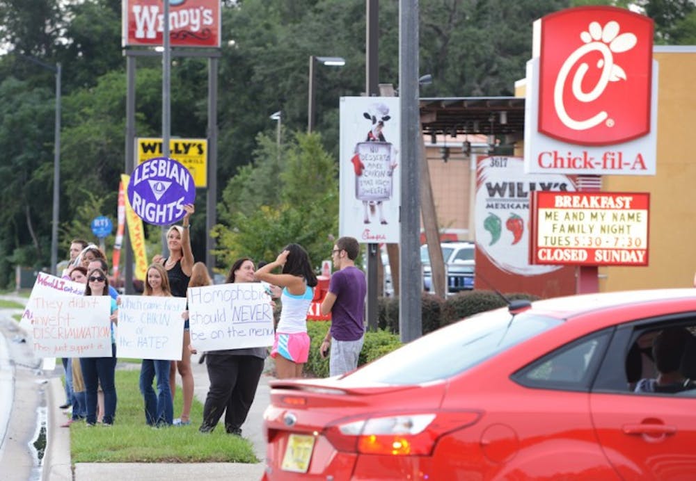 <p>Protesters supporting gay rights stand along Southwest Archer Road in front of Chick-fil-A. Thousands of people flocked to Chick-fil-A to support the restaurant chain’s traditional stance on marriage rights.</p>