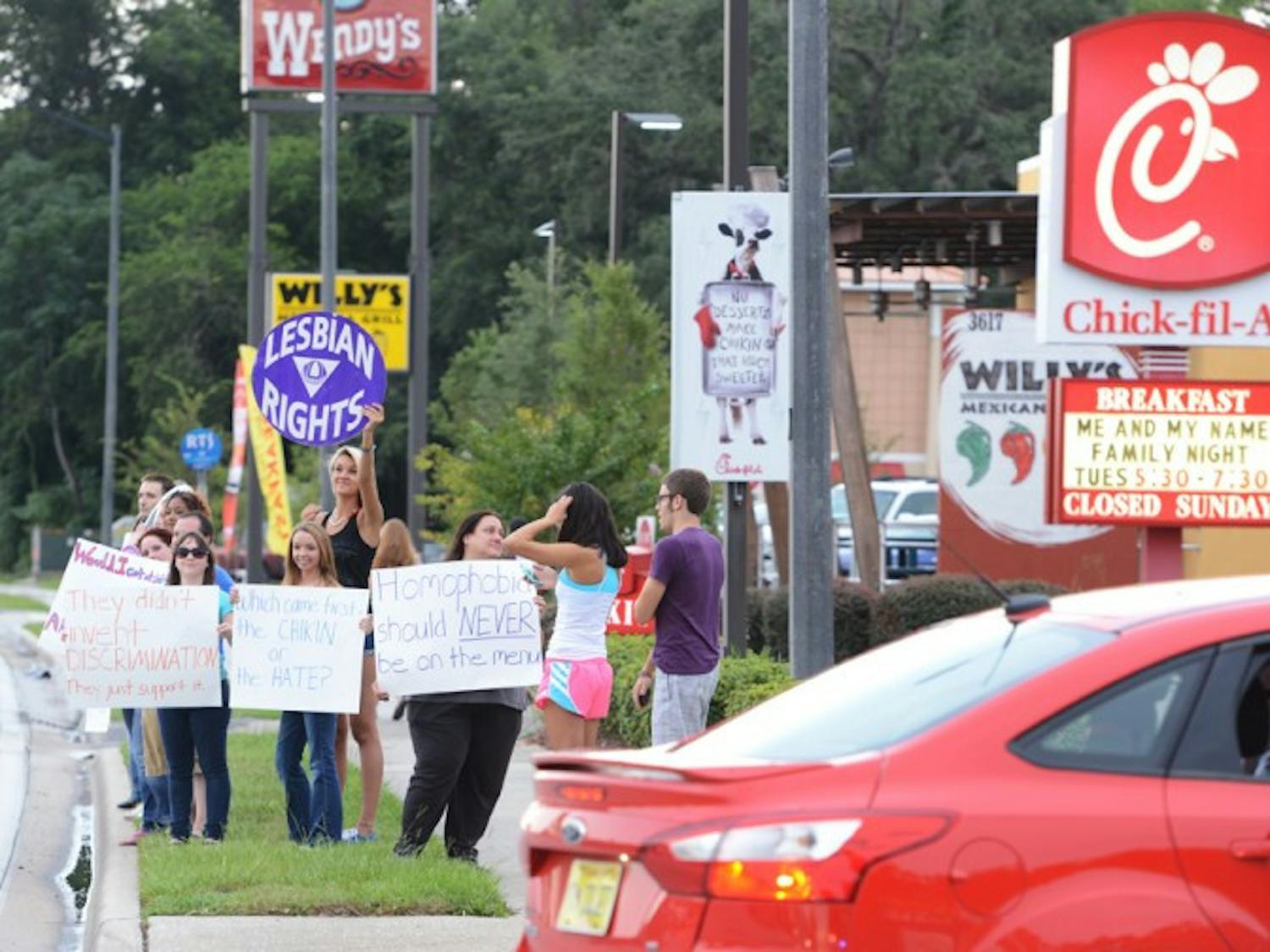Protesters supporting gay rights stand along Southwest Archer Road in front of Chick-fil-A. Thousands of people flocked to Chick-fil-A to support the restaurant chain’s traditional stance on marriage rights.