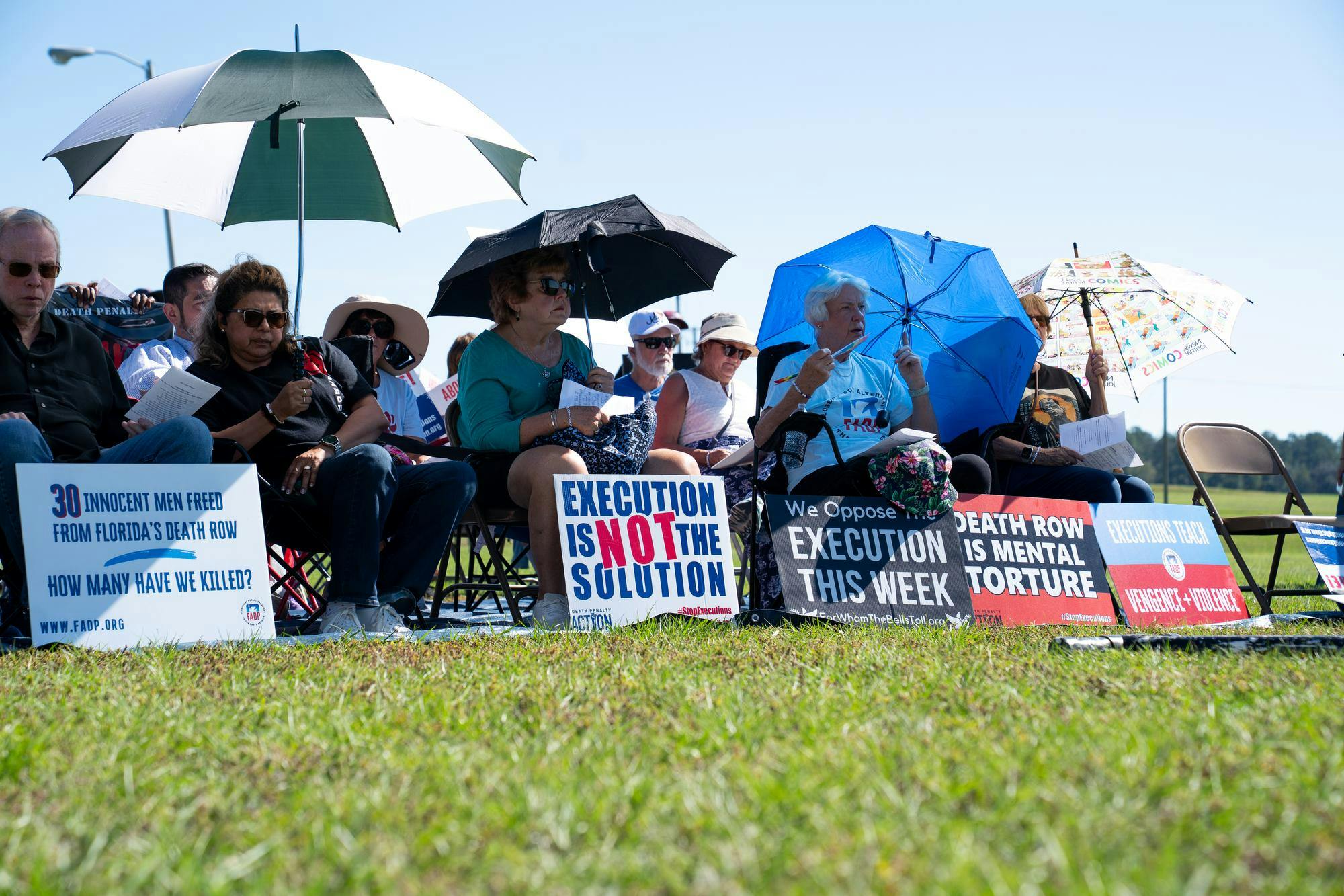 Protestors sit outside the Florida State Prison, Tuesday, Oct. 13, 2026, in Raiford, Fla.