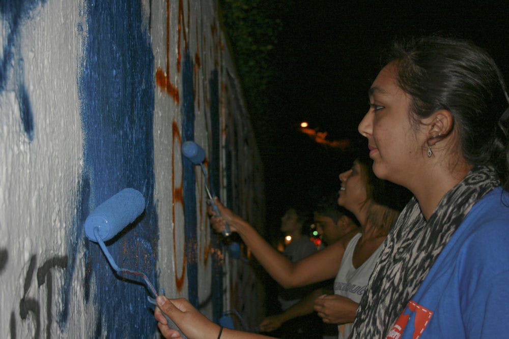 Izma Nadeem, an 18-year-old UF biology freshman, paints the 34th Street Wall on Oct. 1, 2015, to promote Fast-a-Thon. Islam on Campus will hold the event Tuesday at 6:30 p.m. in the Stephen C. O'Connell Center.