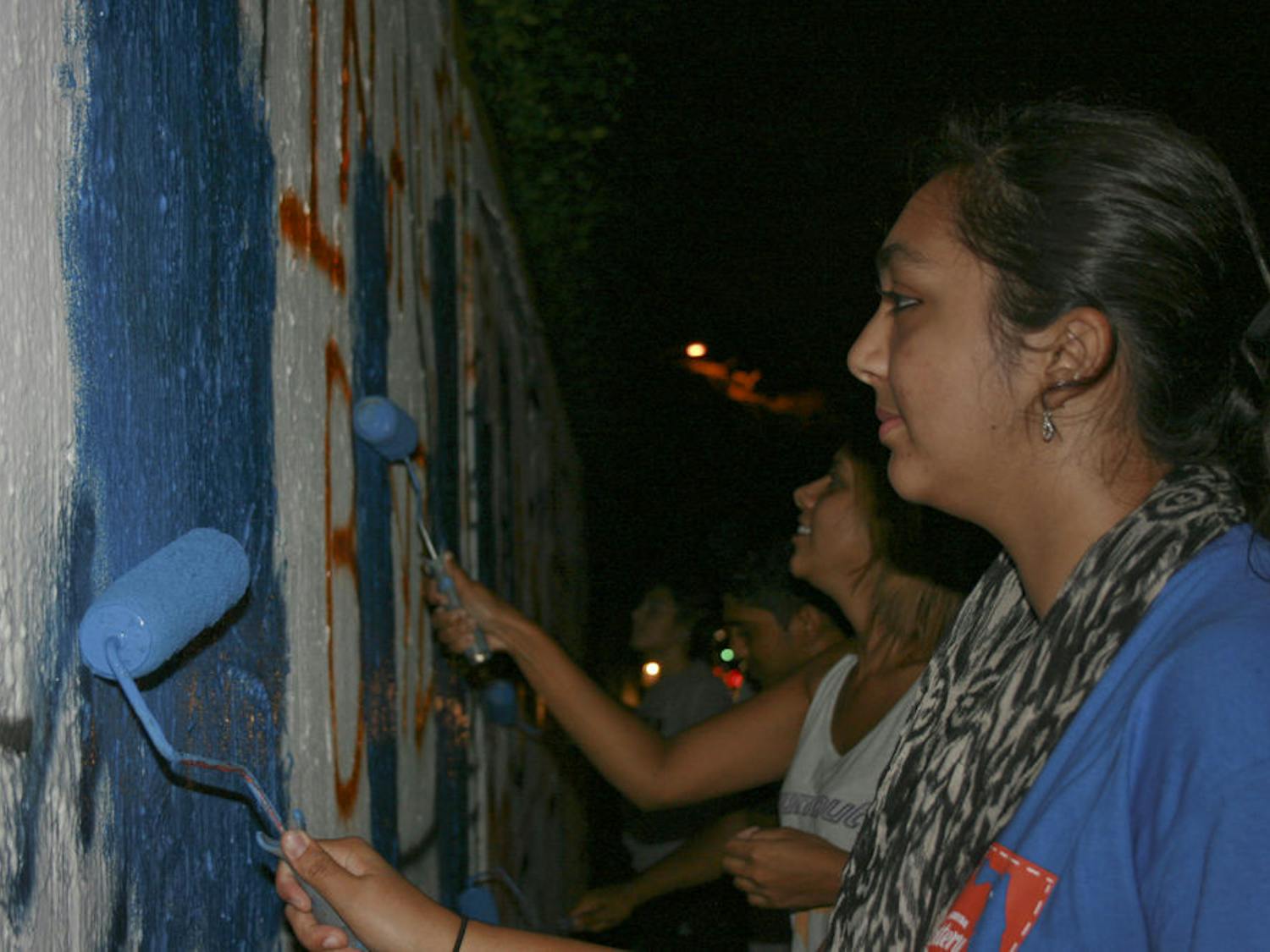 Izma Nadeem, an 18-year-old UF biology freshman, paints the 34th Street Wall on Oct. 1, 2015, to promote Fast-a-Thon. Islam on Campus will hold the event Tuesday at 6:30 p.m. in the Stephen C. O'Connell Center.