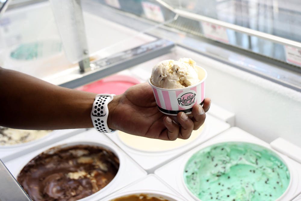 Kenneth Nunez holds a cup of ice cream while he grabs a spoon on opening day of Foxtail Coffee Co.'s new location on Northwest 13th Street, on Wednesday, Sept. 24, 2025. (Photo by Libby Clifton)