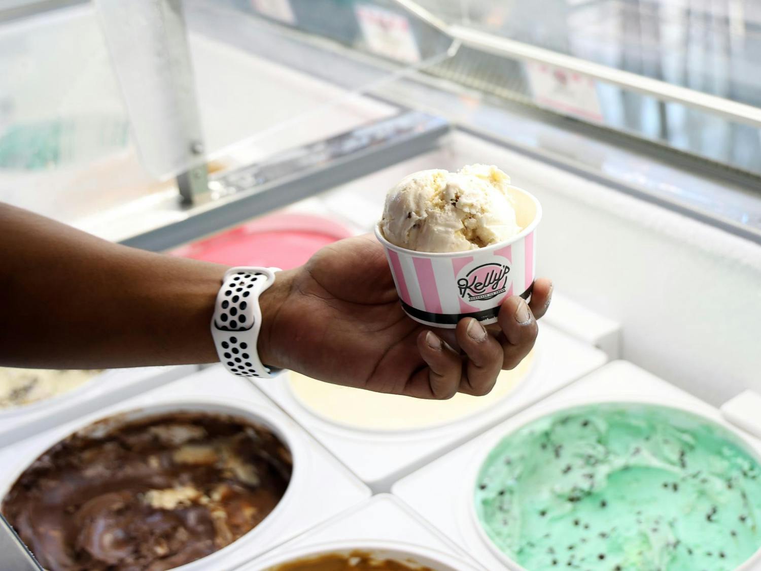 Kenneth Nunez holds a cup of ice cream while he grabs a spoon on opening day of Foxtail Coffee Co.'s new location on Northwest 13th Street, on Wednesday, Sept. 24, 2025. (Photo by Libby Clifton)