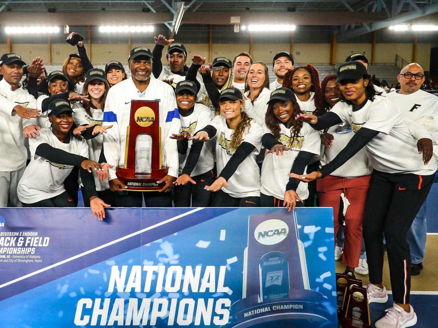 Florida women’s track team and head coach Mike Holloway raise the NCAA Indoor Championship trophy