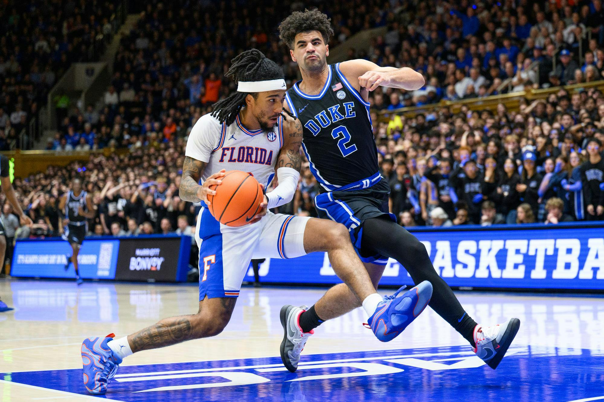 Florida guard Boogie Fland (0) drives against former Duke forward Cameron Boozer (12) during the second half of an NCAA college basketball game, Tuesday, Dec. 2, 2025, at Cameron Indoor Stadium in Durham, N.C.