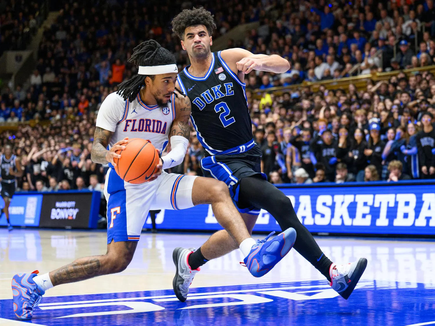 Florida guard Boogie Fland (0) drives against former Duke forward Cameron Boozer (12) during the second half of an NCAA college basketball game, Tuesday, Dec. 2, 2025, at Cameron Indoor Stadium in Durham, N.C.