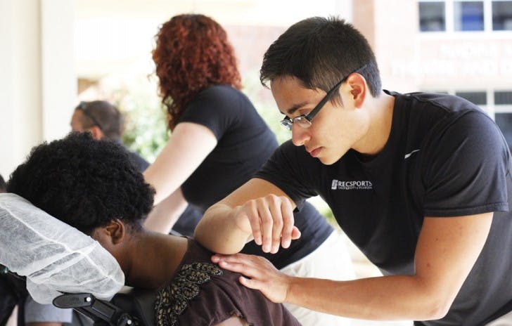 Andres Ramirez, a 23-year-old RecSports employee and food science and nutrition alumnus, massages Jennifer Polexi, a 18-year-old UF marketing sophomore. Polexi waited 15 minutes for her five-minute massage. “It felt like it wasn’t long at all,” she said.